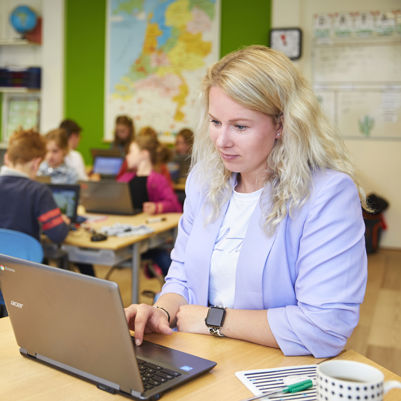 Leerkracht en leerlingen primair onderwijs in de klas Leerkracht en leerlingen primair onderwijs in de klas